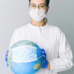Conceptual image of a doctor holding a globe with a mask, symbolizing global health.